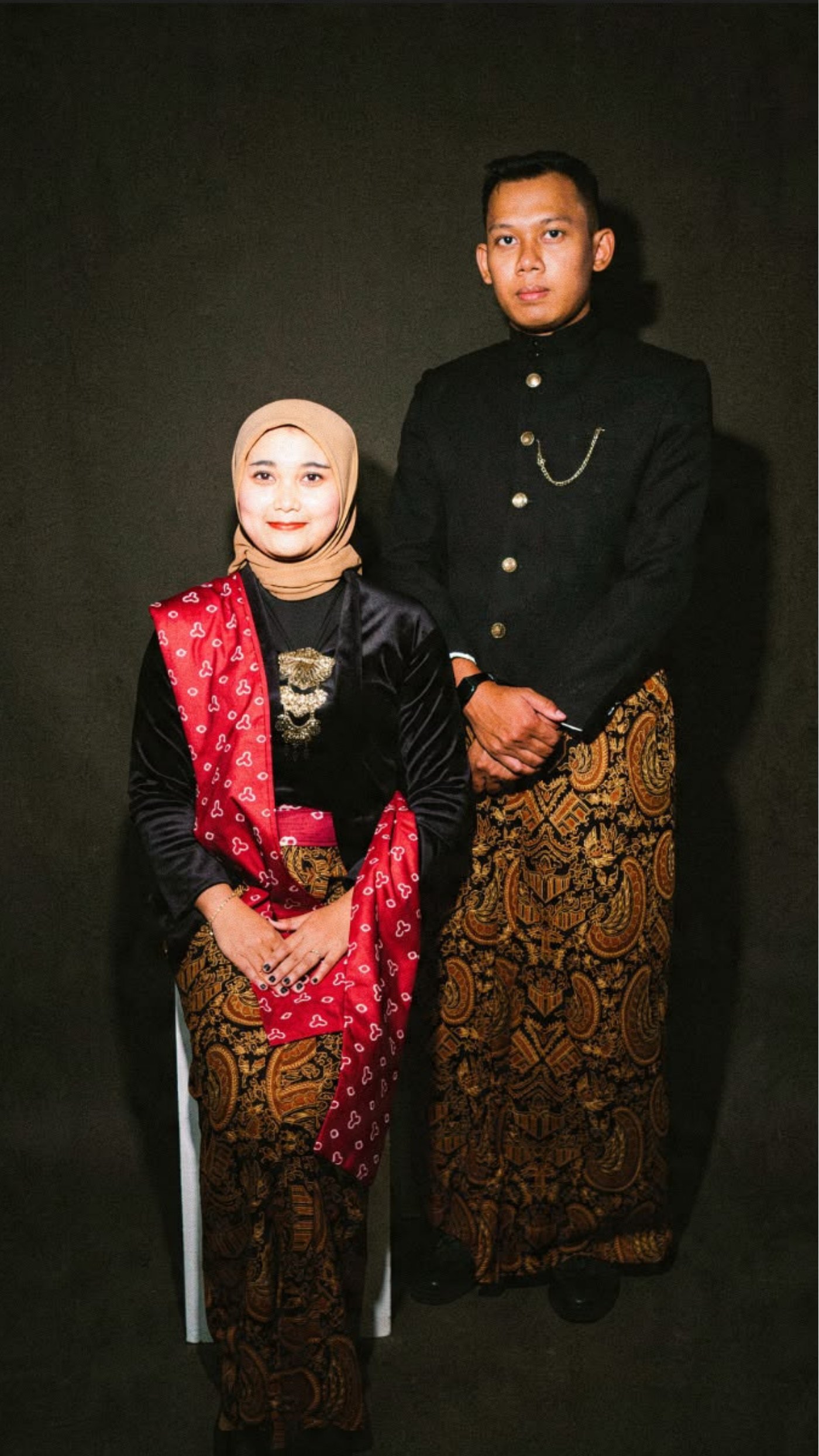 Bagus berdiri di samping Titin yang sedang duduk