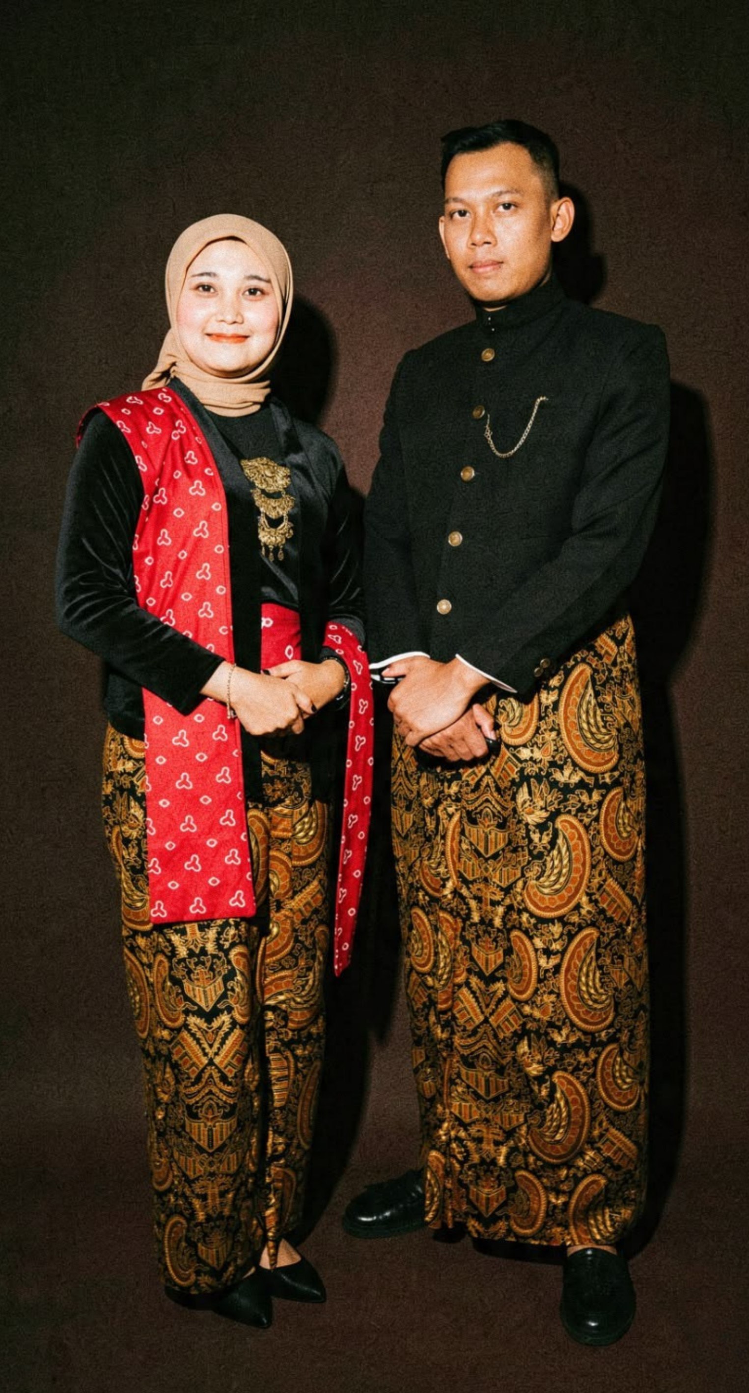 Bagus dan Titin mengenakan busana tradisional bernuansa hitam dan batik